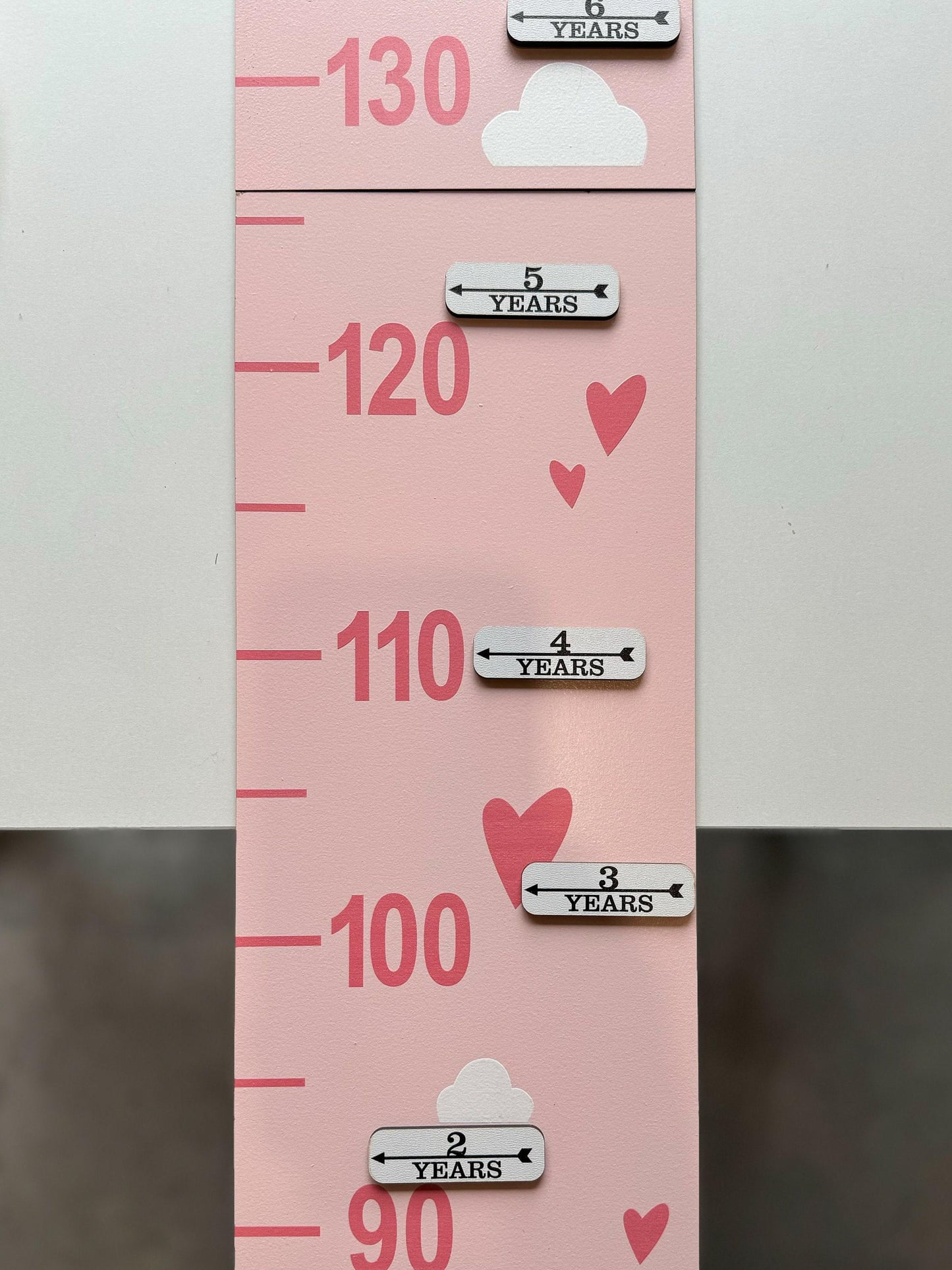a pink growth chart with hearts on it and milestones cards
